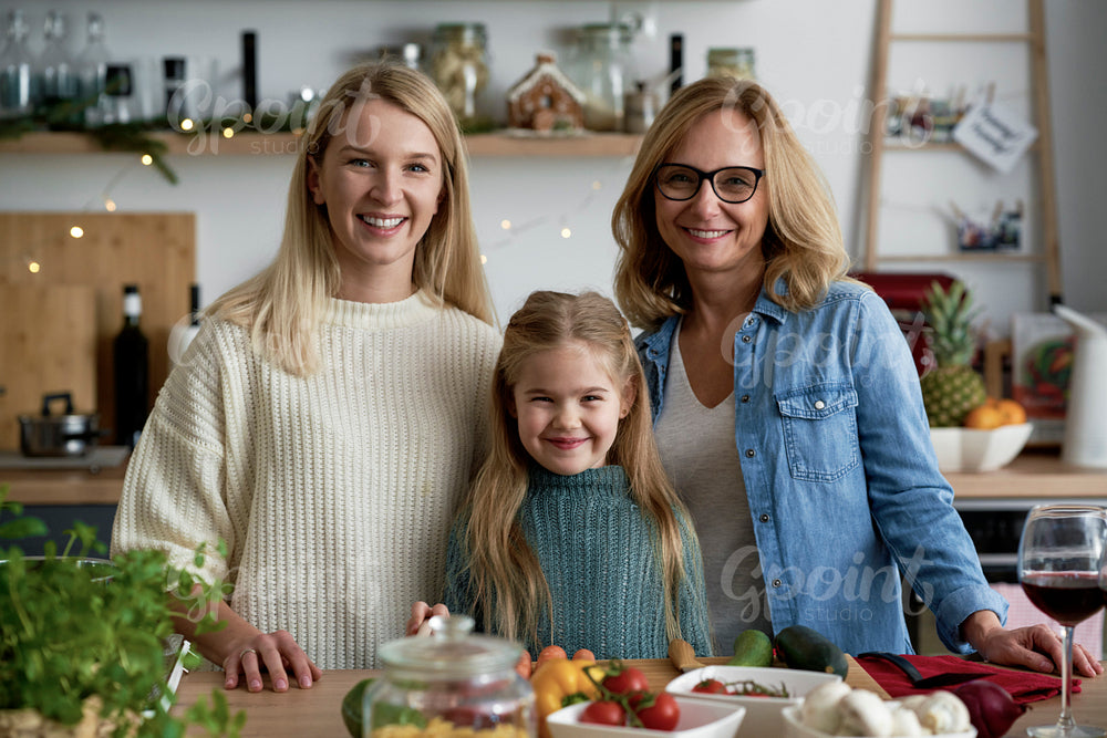 Portrait of three generations of women in kitchen during Christmas time