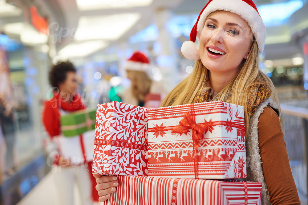Amused woman with a pile of Christmas presents