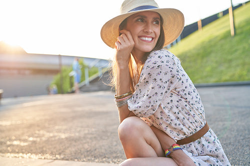 Smiling young beautiful woman in a hat during the sunset