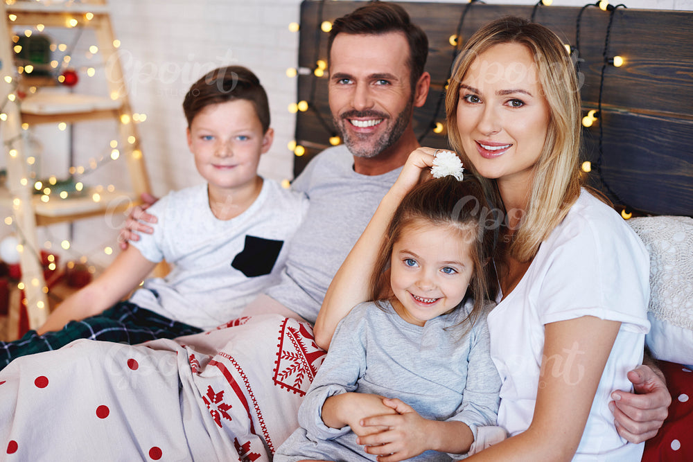 Portrait of family in bed at Christmas