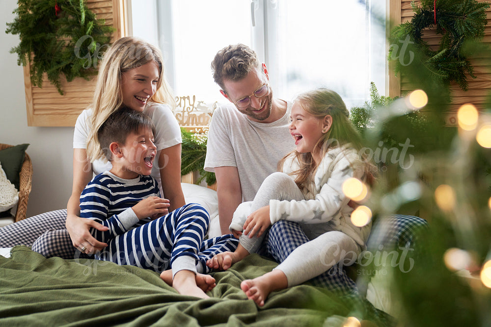 Family spending Christmas morning together in bed 