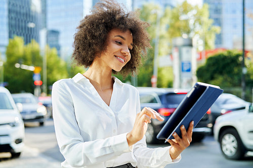 Happy businesswoman using digital tablet in the city