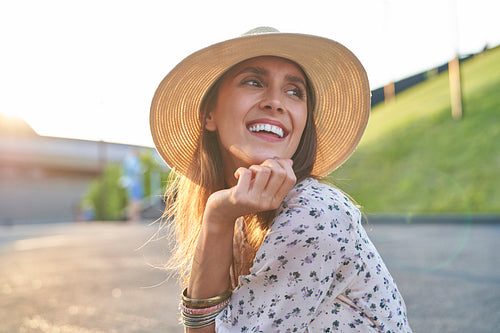 Happy young beautiful woman in a hat during the sunset