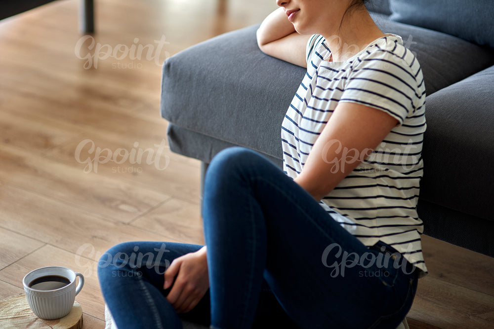 Close up young woman sitting on the floor and thinking.