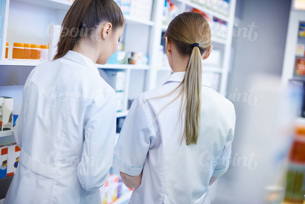 Back view of pharmacists wearing lab coats