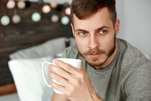 Thoughtful man drinking morning coffee