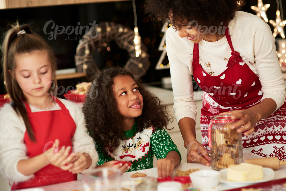 Girls helping mom making cookies for Christmas