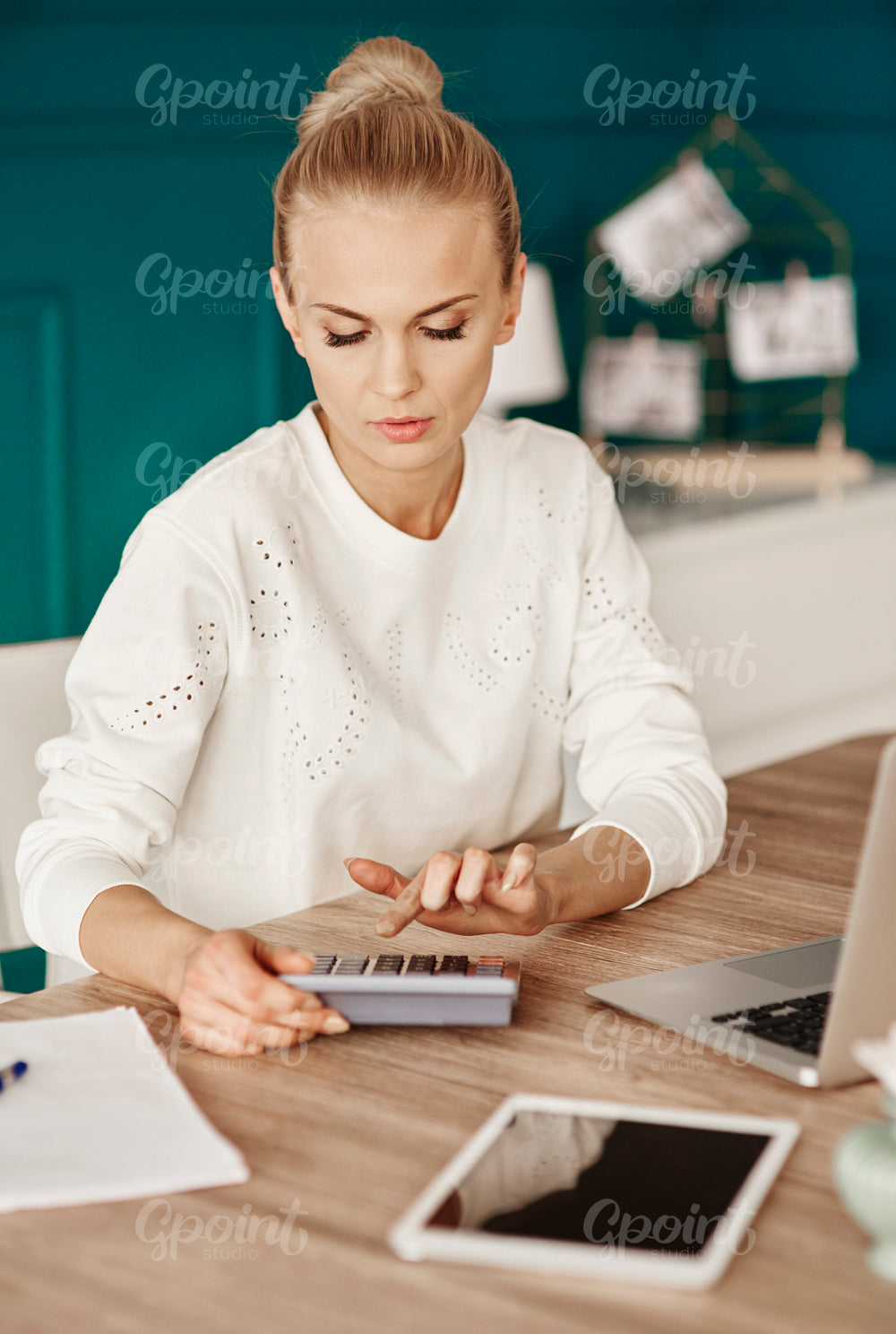 Serious businesswoman calculating her monthly expenses