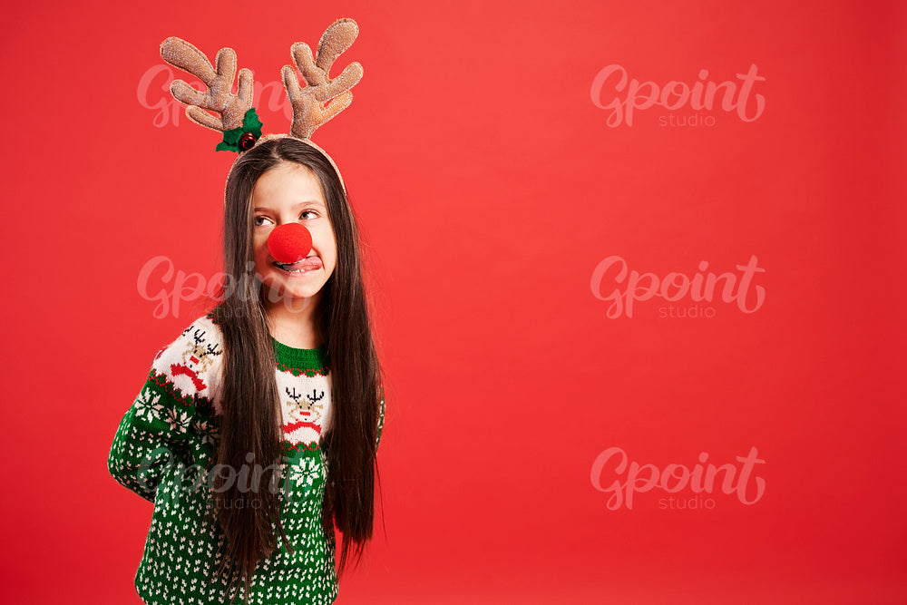Funny girl in Christmas costume on red background