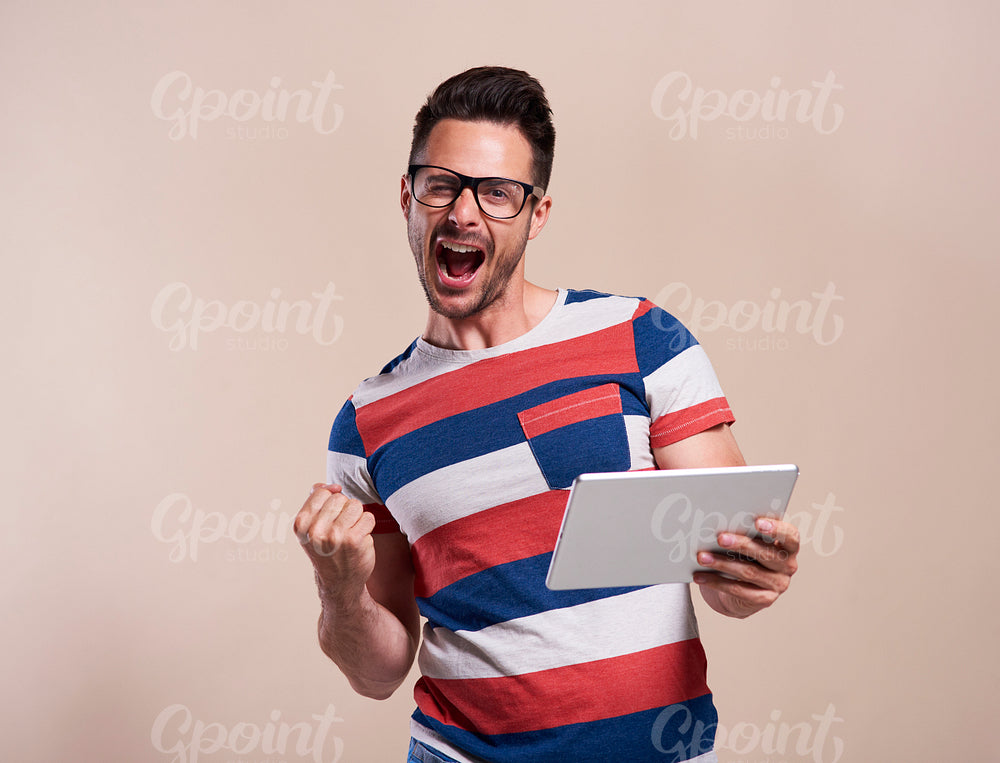 Excited man with tablet in studio shot