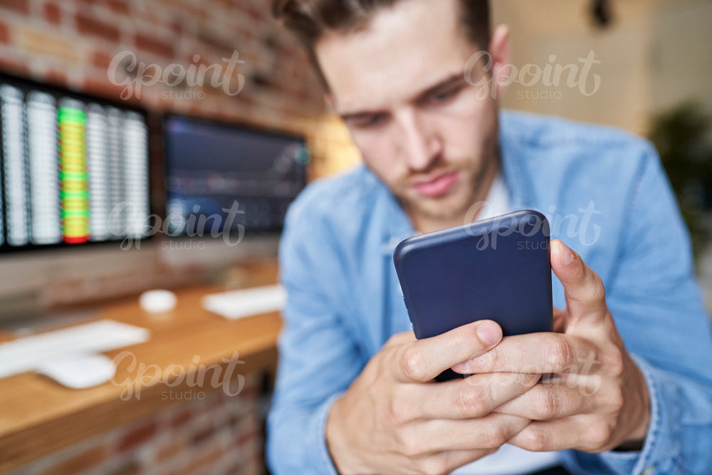 Man using phone to follow stock market