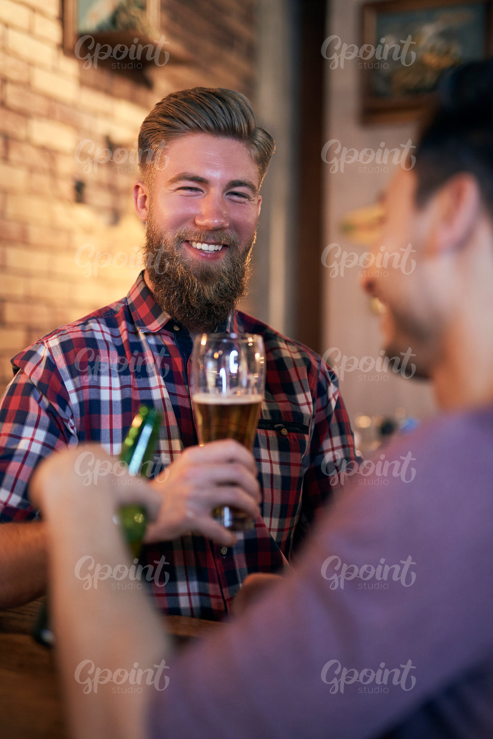 Portrait of smiling man drinking beer in the pub