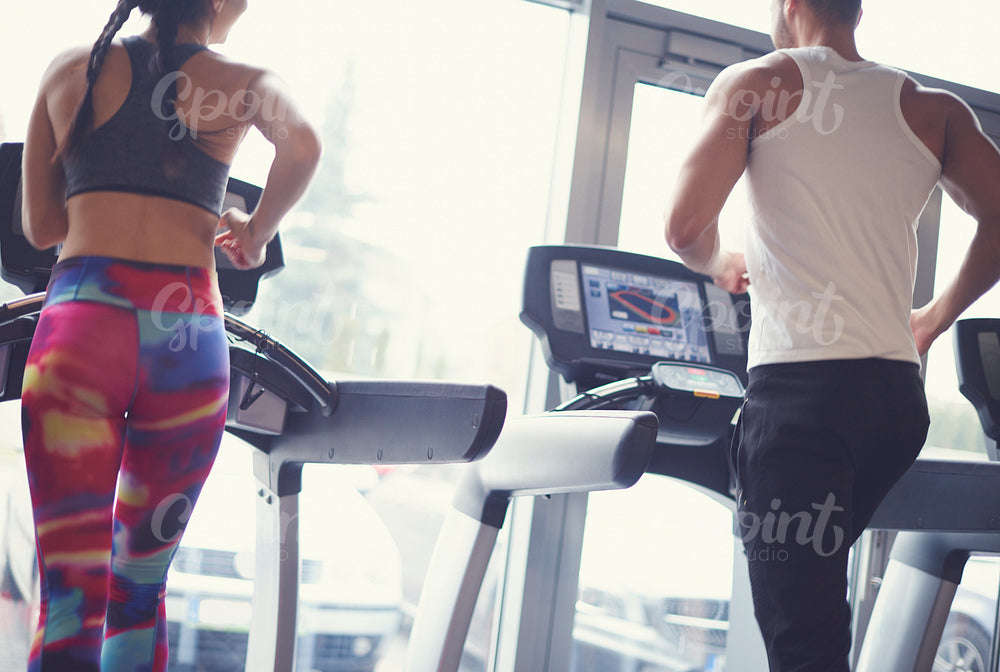 Fit couple exercising on treadmill