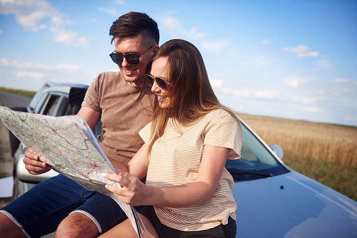 Couple with map choosing the best road for road trip