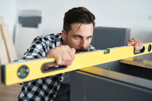 Man checking the furniture levels using a spirit level