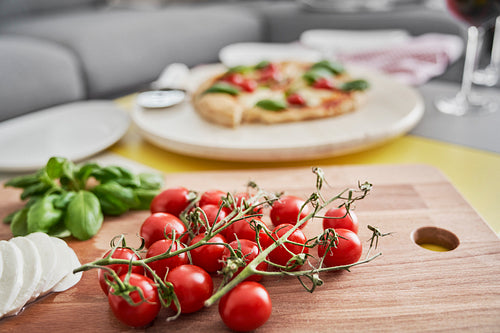 Close up of cherry tomatoes and pizza in the background