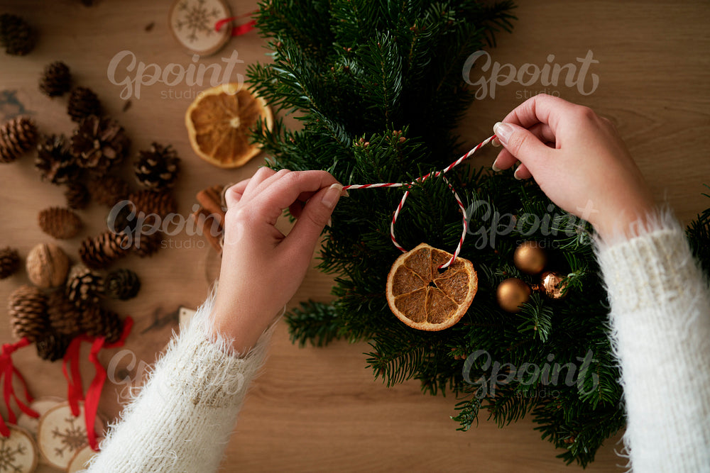 Top view of hands decorating Christmas wreaths