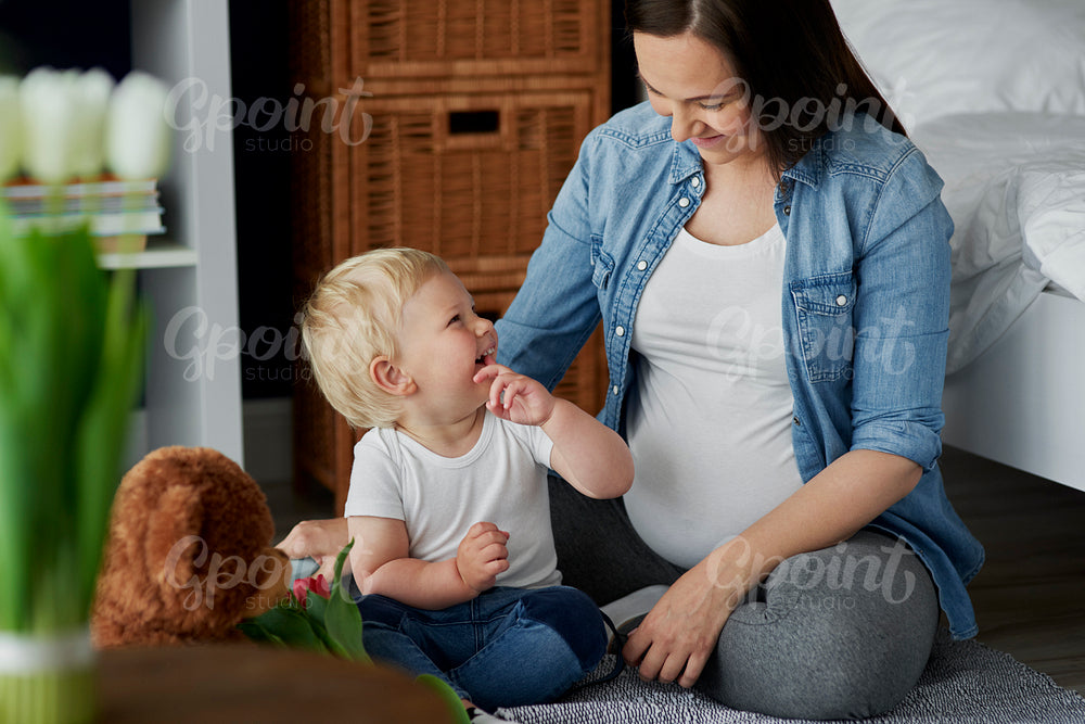 Pregnant woman spending time with her son toddler