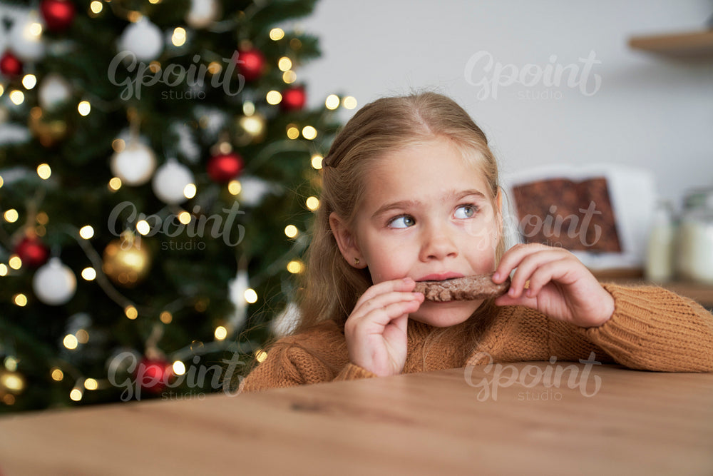 Cute girl eating homemade gingerbread cookie