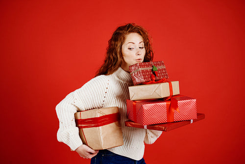 Girl carrying a stack of christmas presents