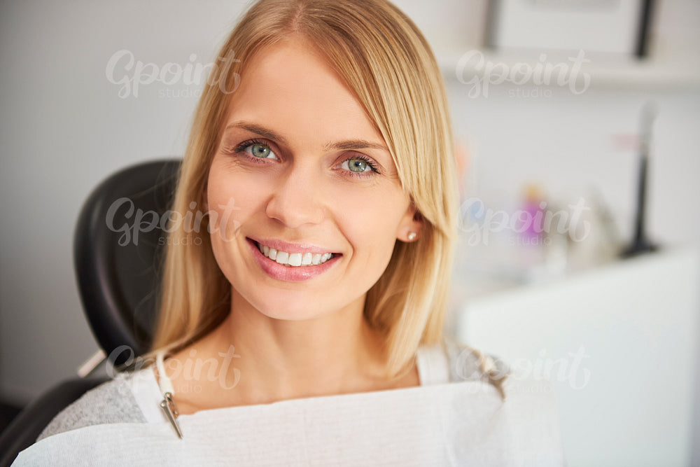 Portrait of pleased and smiling woman in dentist's clinic
