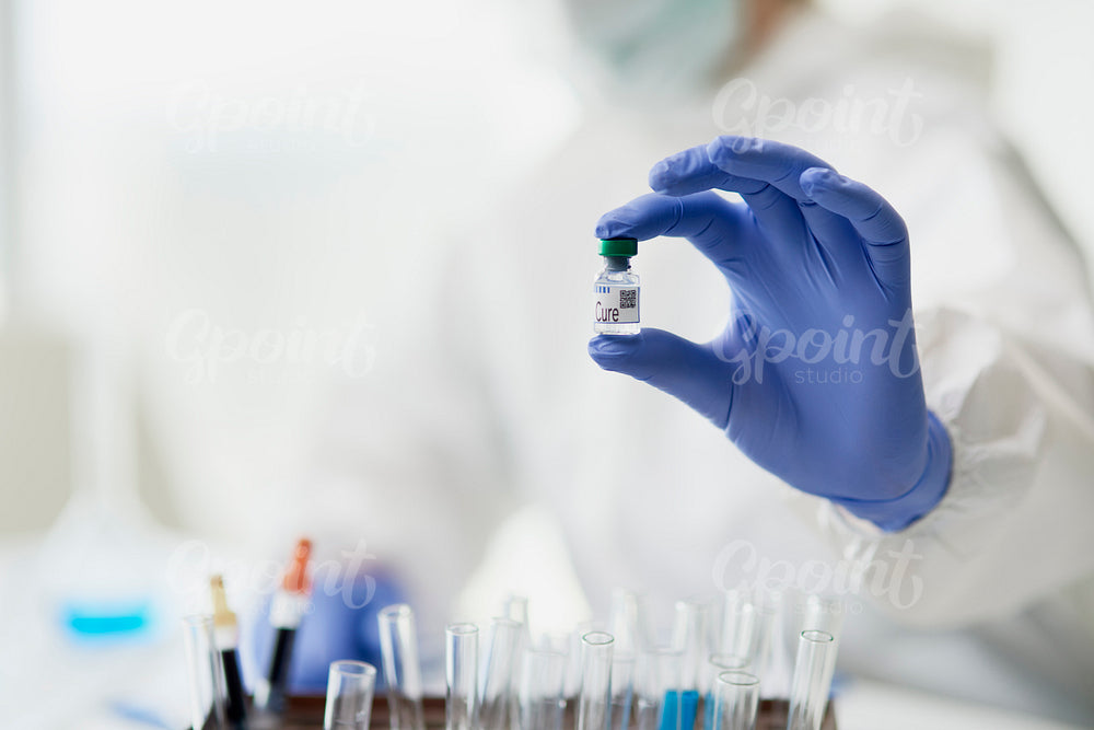 Hands in protective gloves holding a medical cure