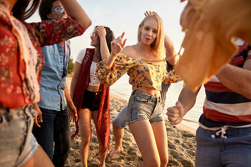 Group of young people dancing at sunset