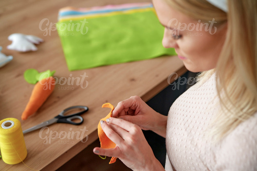 Top view of woman sewing Easter decorations