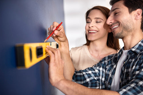 Couple preparing wall for new decorations