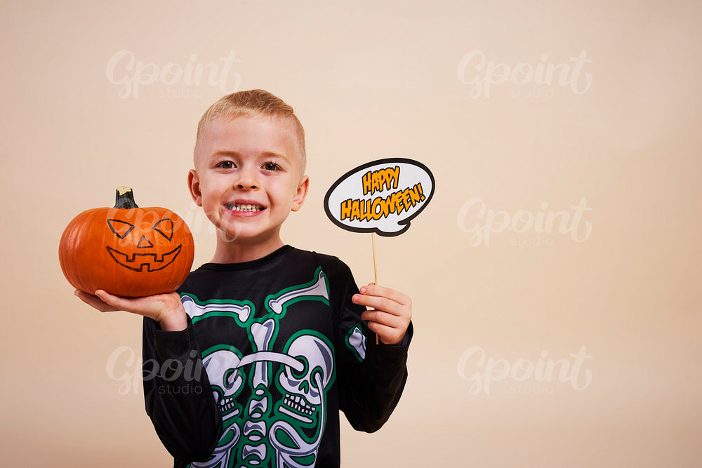 Smiling boy start decorating the pumpkins