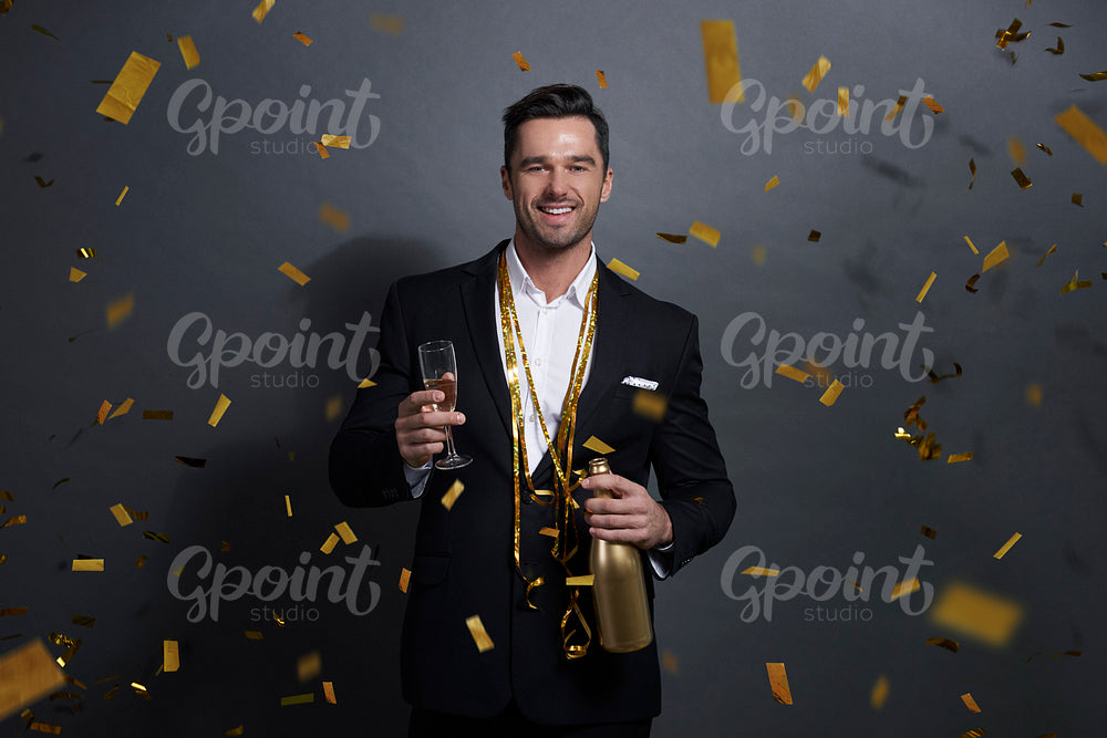 Portrait of smiling man drinking alcohol at studio shot