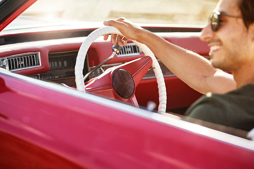 Close up of  happy man driving a red vintage car