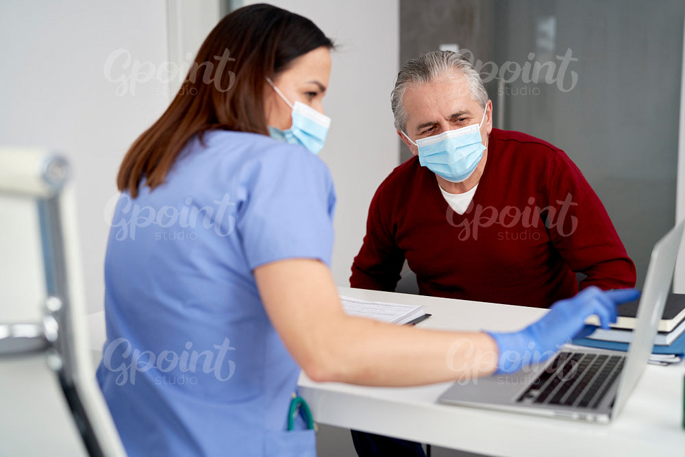 Female doctor shows patients results on a laptop