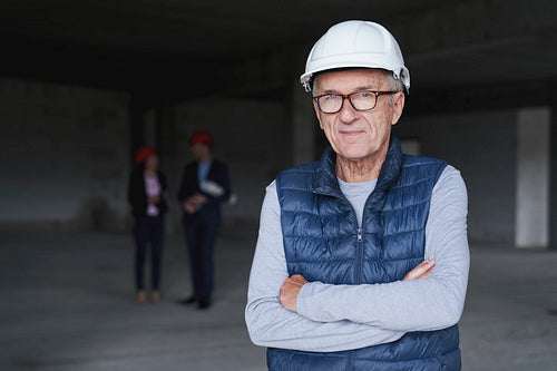 Portrait of senior man standing on construction site