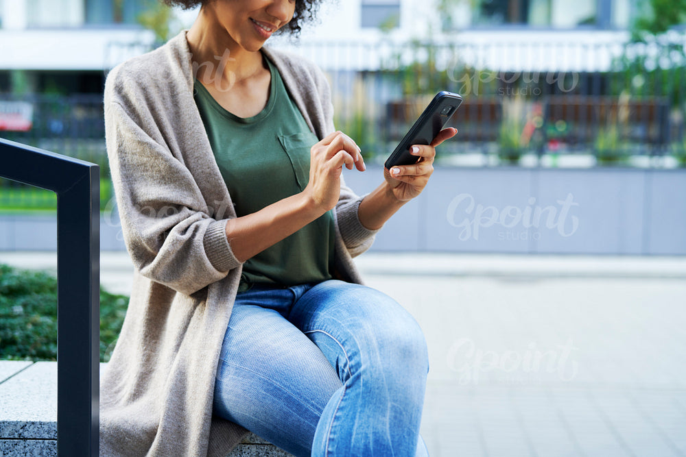 Close up of woman sitting and scrolling on the phone