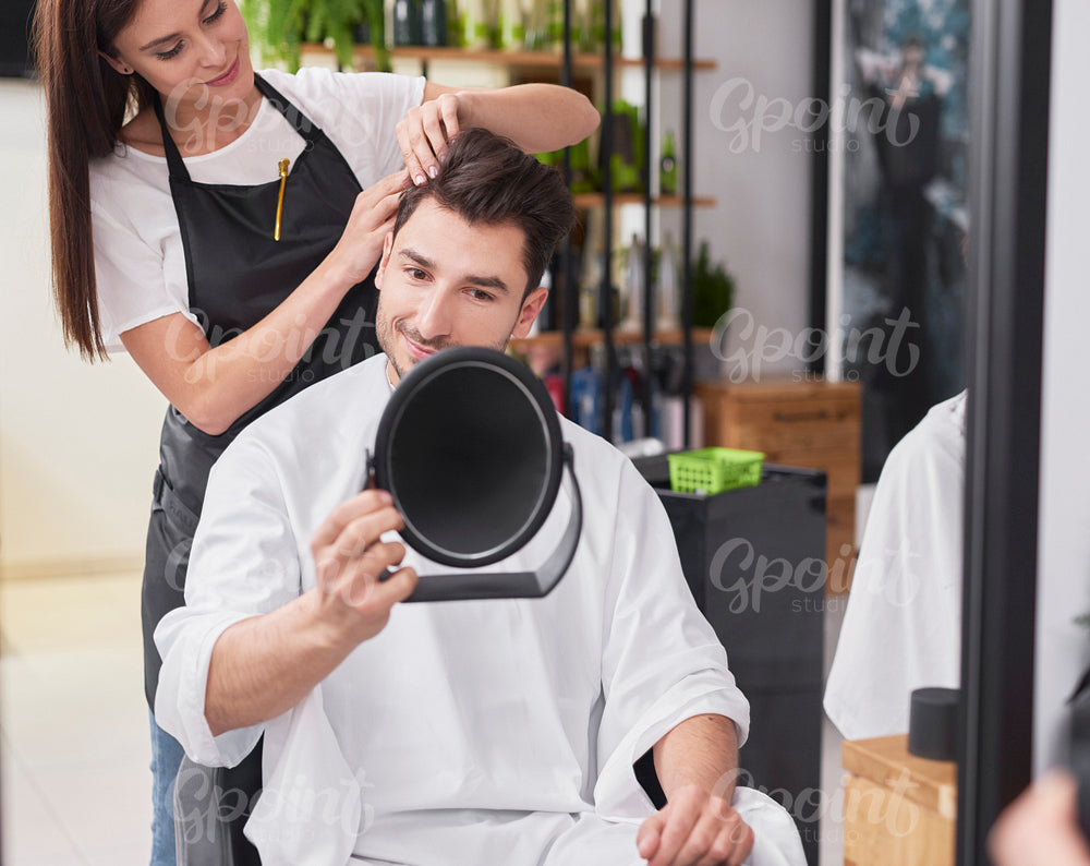 Female hairdresser creating fashionable hairstyle her male customer