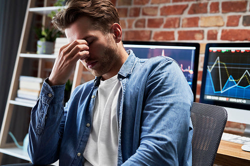 Young adult man is tired of work with finances