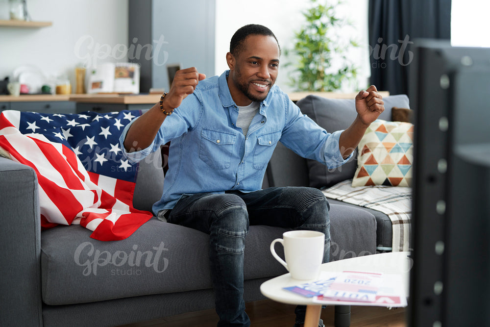 Man cheering on front of TV