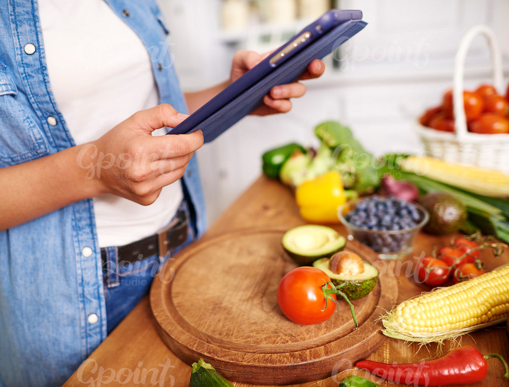 Close up of woman with digital tablet in the kitchen
