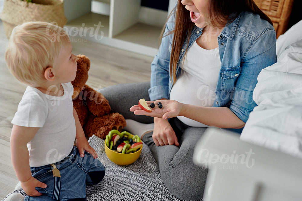 Mother having a fruity snack for her toddler baby