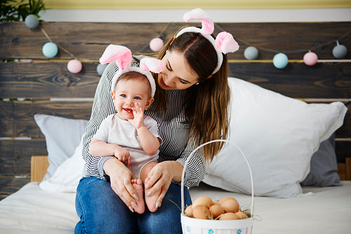 Mum and baby girl celebrating Easter morning in bed