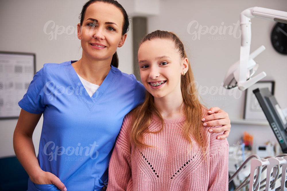Portrait of smiling orthodontist and child in dentist's office