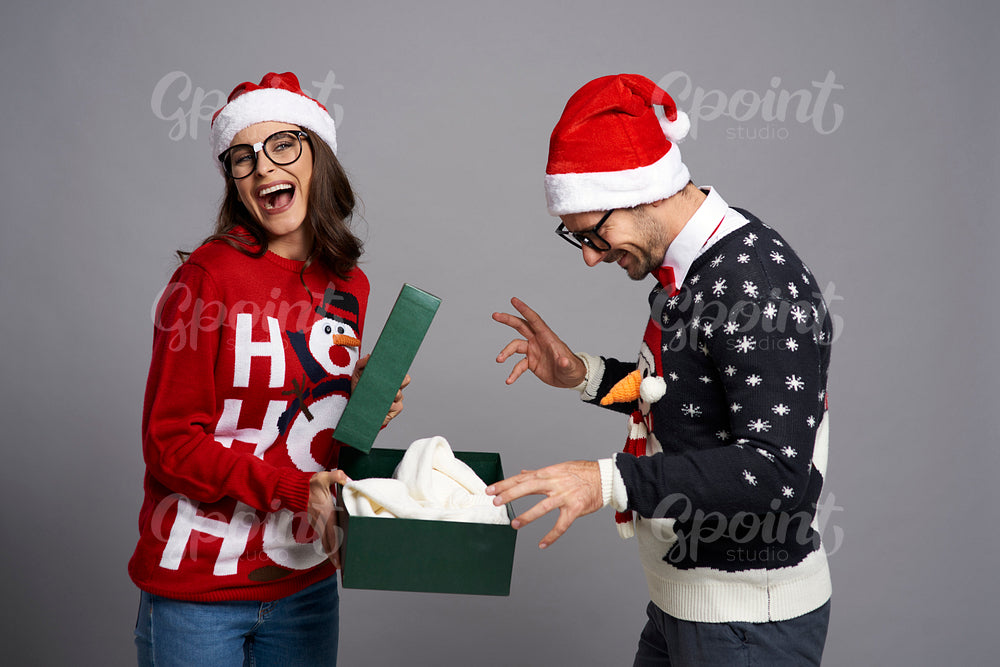 Happy couple opening Christmas gift