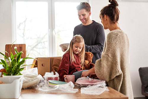 Caucasian family packing kitchen stuff in new house
