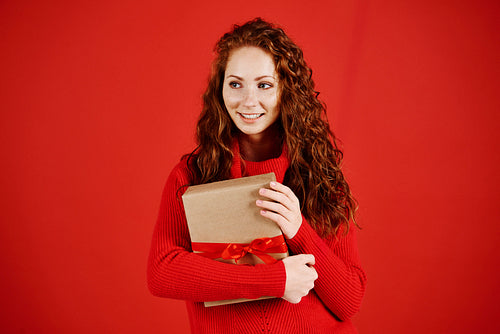 Smiling girl with christmas present looking at copy space