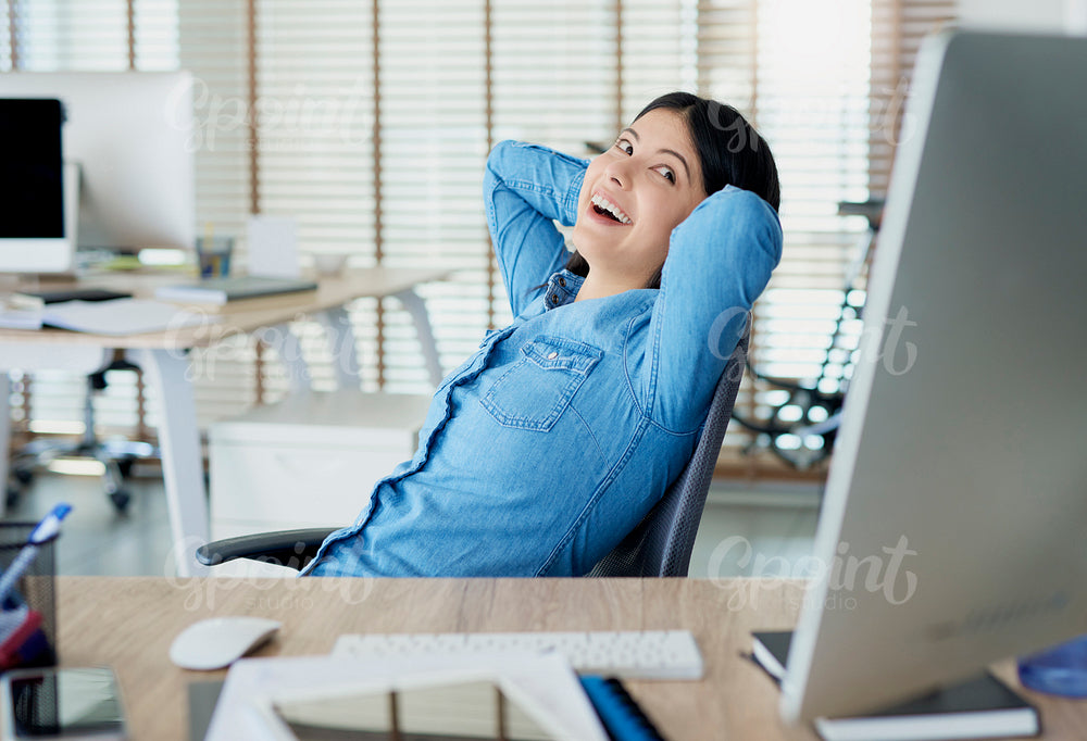 Satisfied Asian woman having a break in the office