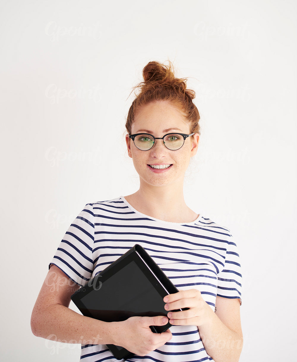 Portrait of young woman holding a tablet at studio shot