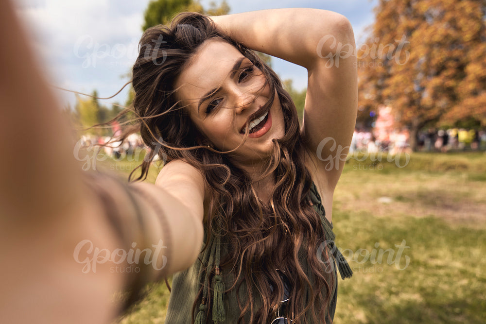 Smiling caucasian woman making selfie at music festival