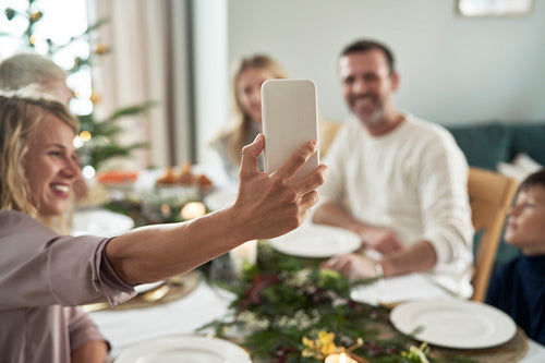 Caucasian family of different generation taking selfie over Christmas table