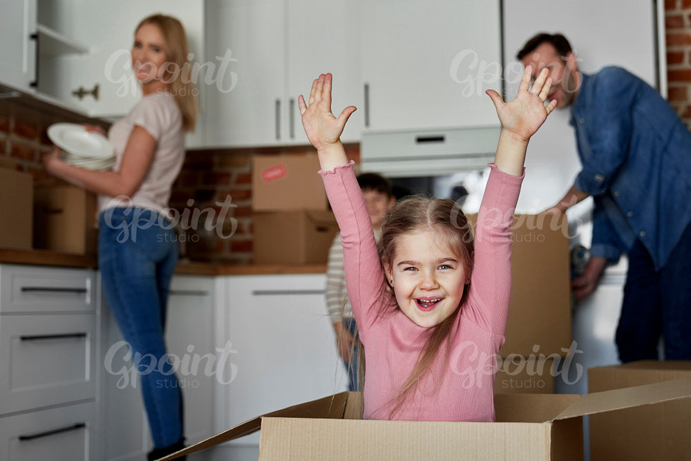 Portrait of a playful girl in a cardboard box while moving